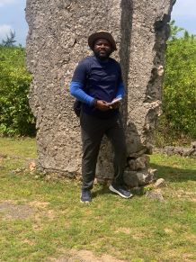 Akinbowale stood in front of a ruin